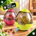 Two egg-shaped automatic pet feeders on a wooden table, one pink and one lime green, filled with kibble and showing a blue dispensing slot. A black promotional banner in the top left reads 'Upto 25% OFF' with a paw print.