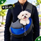 A small white dog sits in a blue and gray mesh pet carrier worn crossbody on a person outdoors. The carrier has a bright blue mesh front panel, dark gray mesh top, and black trim.