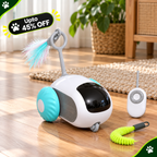 A small white and turquoise robotic cat toy with a black face window, a feather wand, and a separate remote controller on a wooden floor. A green coiled toy is also placed nearby.