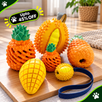A set of colorful dog chew toys shaped like fruits, including orange spiky pineapple and durian toys, a yellow mango-shaped toy, a small yellow spiky ball, and a blue strap, arranged on a wooden cutting board in a home setting.